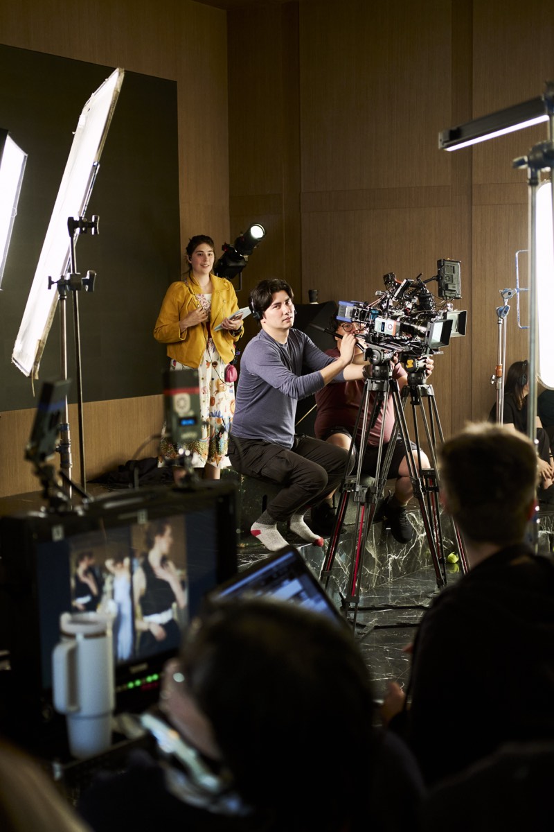 Actors running a scene while the crew works around them.
